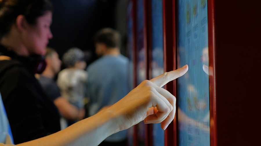 person orders typing on modern interactive board in cafe