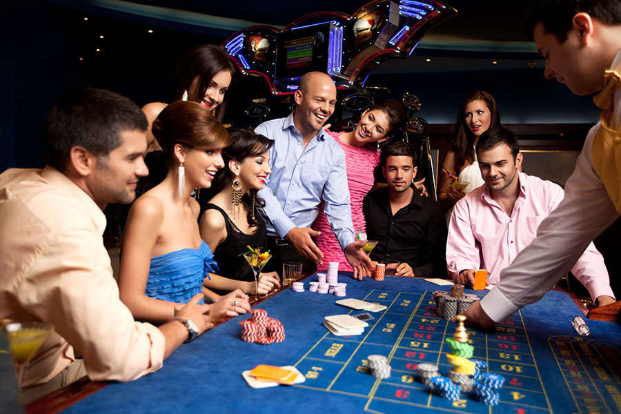 amigos felices jugando a la ruleta en un casino | Touch Dynamic